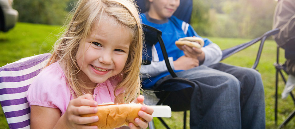 Smiling blond girl with a sandwich for snack