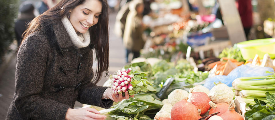 A woman quarries in the vegetable and spice mart in the center of Bolzano