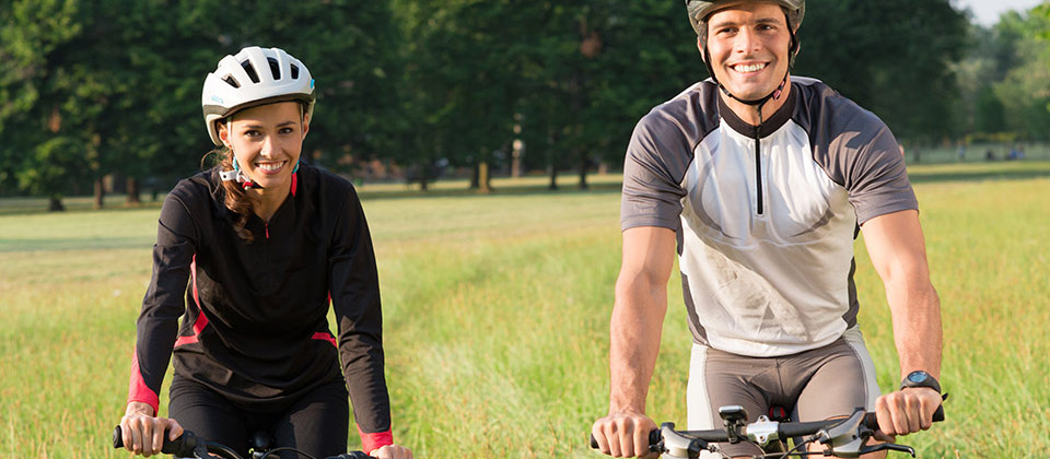 Una coppia in Alto Adige su un percorso mountainbike in mezzo a un prato