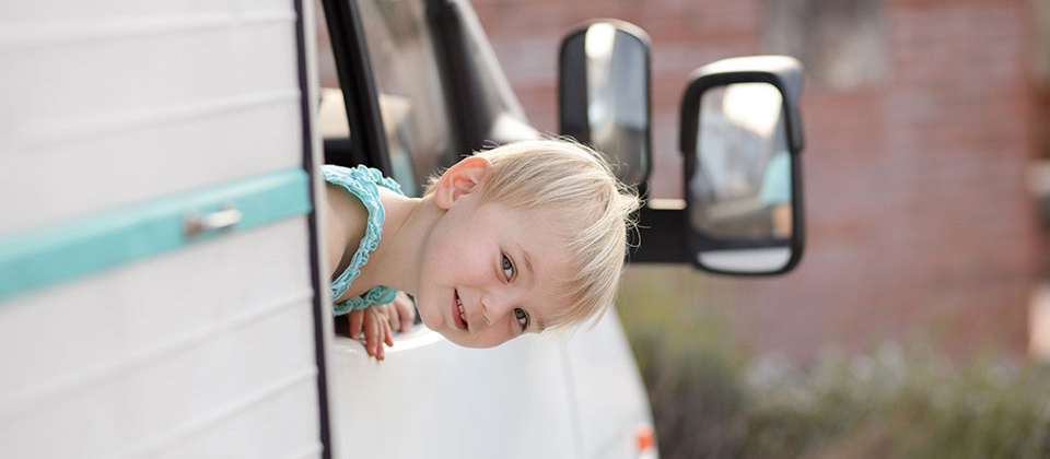La testa di un bimbo biondo si affaccia dal camper